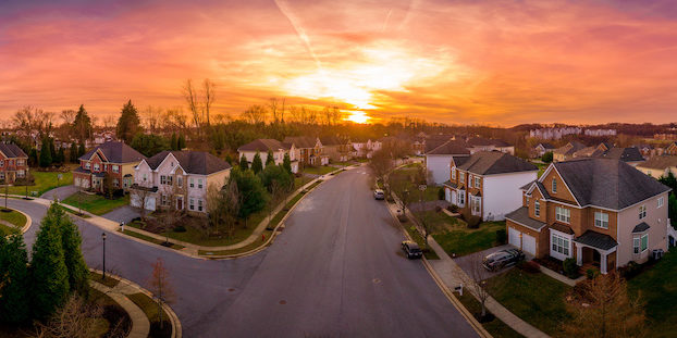 Aerial sunset panorama view of cul-de-sac (dead-end) luxury upscale residential neighborhood gated community street in Maryland USA, American real estate with single family homes brick facade